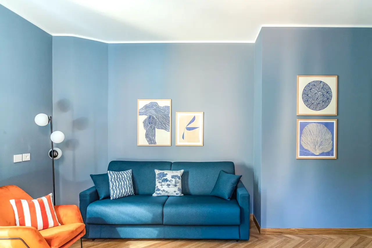 Divano blu e poltrona arancione in soggiorno