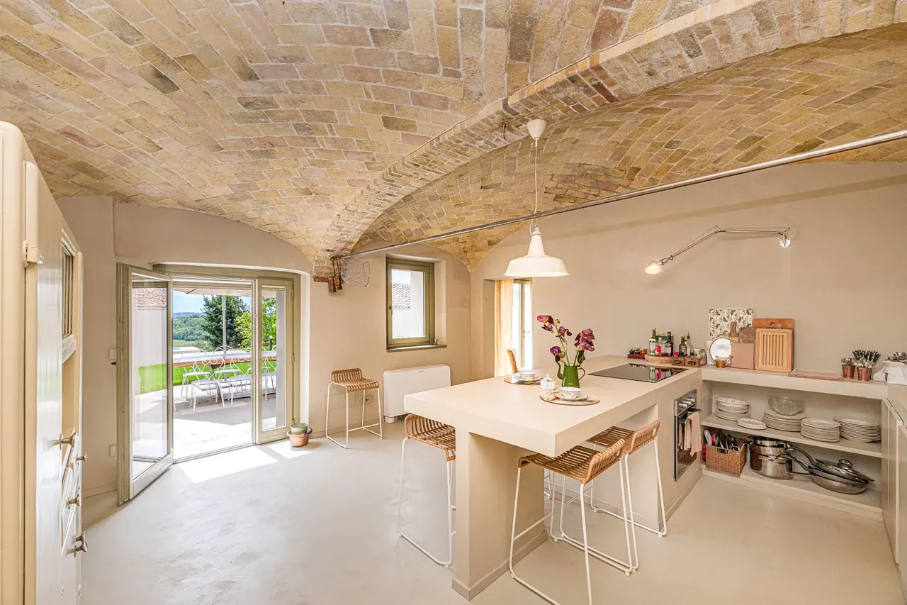 Cucina rinnovata con piano in legno e pareti materiche